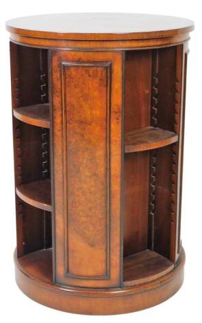 A 20thC burr walnut finish CD tower, of cylindrical form, with panelled sides broken by openings for books or CDs with a rotating action, 88cm H, 60cm Dia.