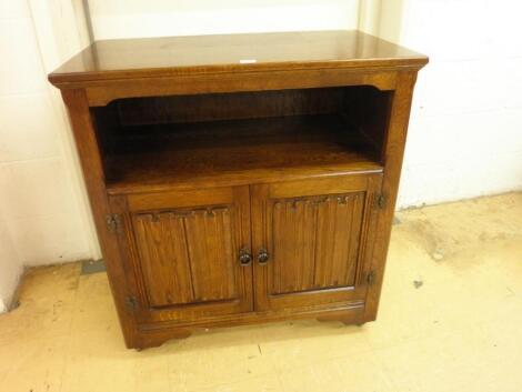 An oak side cabinet with a recess above two doors