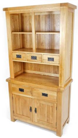 A light oak finish Wren open display cabinet, with five drawers and double cupboard on stiles, 189cm H, 100cm W. 45cm D.