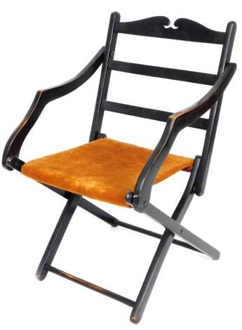 An early 20thC ebonised folding chair, with horizontal splats and overstuffed seat, in orange material, when closed 71cm H.