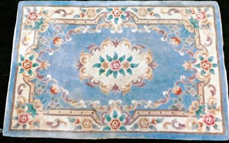 A hand cut Chinese wool rug in floral pattern, predominately in blue and cream, 184cm x 122cm.