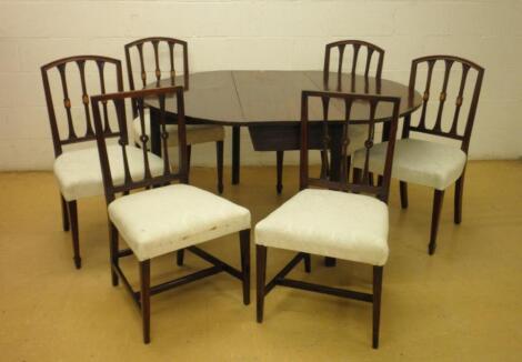 An early XIX century mahogany oval drop leaf table and six XIX century dining chairs