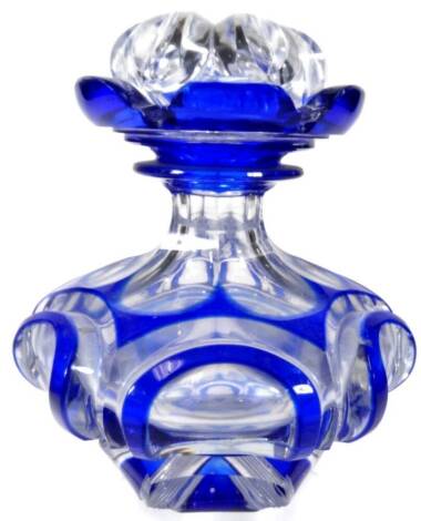 An early 20thC Bohemian blue and clear flash glass bottle and cover, of compressed circular form set with scrolls with stopper lid, 16cm H.