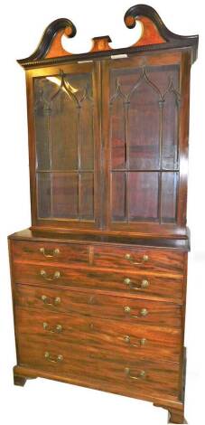 A George III mahogany secretaire bookcase, the upper section with a swan neck pediment, set with Sheraton style floral patera above a pair of astragal glazed doors, with two short and one long dummy drawers revealing a secretaire, with fitted interior abo