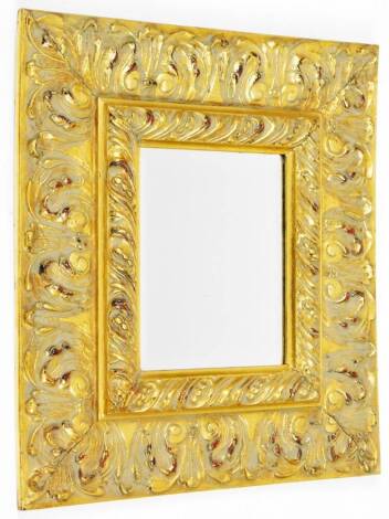 A heavy gilt wood Florentine mirror, of rectangular form, with raised gadrooned outline to the plain glass, with a lowered carved scroll outer border, 52cm H, 46cm W, 5cm D.