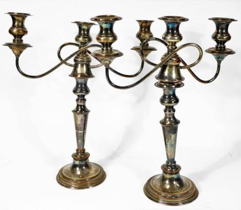 A pair of early 20thC Old Sheffield plate three branch candelabra, each with entwined attachments, tapering stems and stepped bead lined circular feet, 45cm H, and an elaborated brass door knocker. (3)