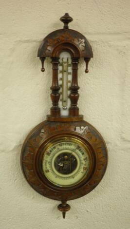 A late Victorian carved walnut aneroid barometer