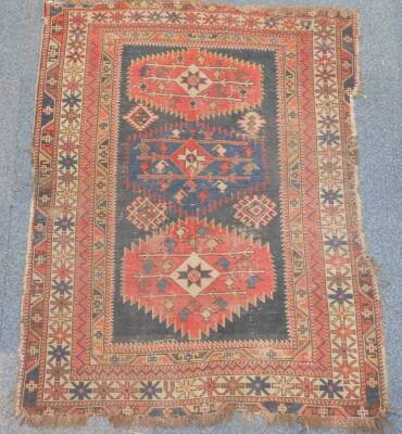 A Caucasian rug, of geometric design with two central medallions, and centre star gul enclosed within repeat borders with stars, blocks and hooks, 152cm x 112cm. (AF) Auctioneers Note: Rug has live moth, and all are as found. Viewing is strongly recommen