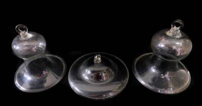 A pair of Victorian glass cloches, or smoke domes of bell form, with an everted rim, 29cm H, 26cm Dia, together with a further glass cloche, of compressed circular form, 30.5cm Dia. (3)