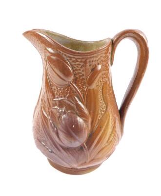 A late 19thC Staffordshire relief moulded jug, brown glazed moulded with flowers, 18cm H.