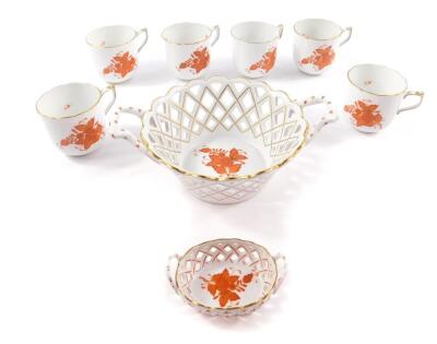 A Herend porcelain circular twin handled basket, decorated in the Apponyi pattern, together with a small oval twin handled basket and six coffee cups. (8)