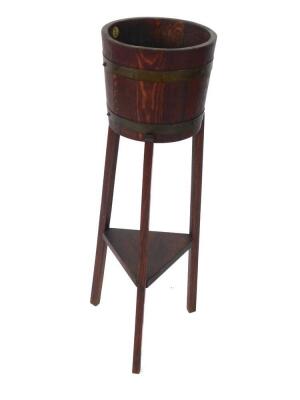 An early 20thC oak and brass bound jardiniere on stand, by R.A Lister & Co. Ltd, Dursley, of bucket form raised on three square tapering legs united by an undertier, 92cm high