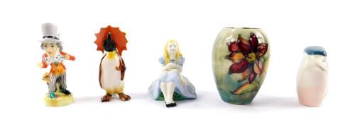 Two Alton porcelain figures modelled as Cinderella and The Mad Hatter, Beswick figure of a penguin with an orange umbrella, Royal Dux porcelain figure modelled as a kingfisher, and a Moorcroft pottery vase of ovoid form decorated with flowers, impressed m