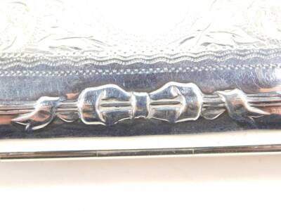 A George V silver purse, with tan leather interior, embossed with bows and engraved with foliate scrolls, oval reserve monogram engraved, with chain suspension, Birmingham 1918, 3.10oz all in. - 2