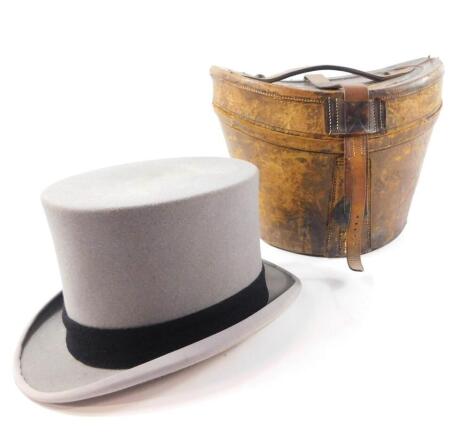 A grey wool felt top hat by Herbert Johnson, 38 New Bond Street, London., inner length 7 7/8", 6 1/2" wide, in a vintage tan leather case, with railway luggage labels for Kings Cross, Doncaster, etc.