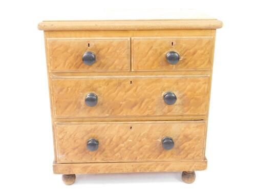 A Victorian scumbled pine chest of drawers, with two short over two long drawers, raised on turned feet, 85cm H, 79cm W, 47cm D.