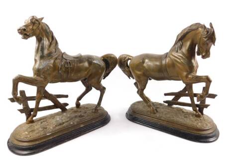 Arthur Waagen (German, 1833-98). A pair of bronzed spelter figures of horses, modelled in prancing pose against a fence, raised on an oval naturalist ground, on an ebonised base, 37cm H, 39cm W.