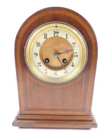 A late Victorian mahogany cased mantel clock, circular brass dial, with enamel chapter ring bearing Arabic numerals, eight day movement with coil strike, stamped XL serial number 686248, the case of domed form with satin wood cross banding and box wood in