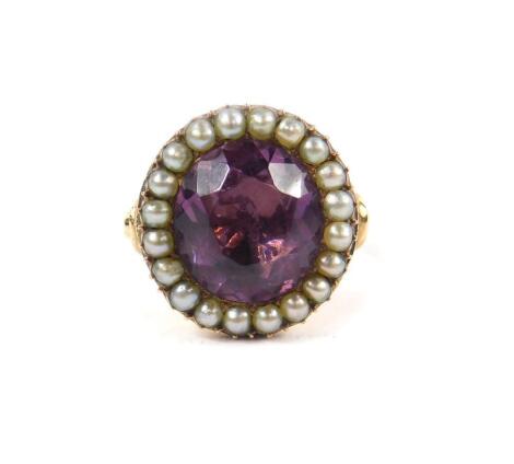 A 19thC amethyst and seed pearl ring, set in closed back yellow metal, size S, 7.8g.