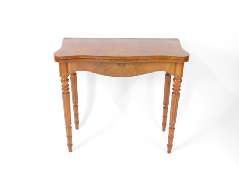 A burr walnut serpentine fold over tea table, raised on turned and fluted legs, 77cm H, 84cm W, 42cm D.