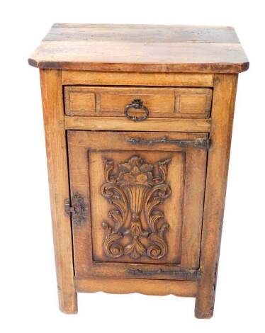 An oak pot cupboard, with a canted rectangular top, over a frieze drawer, above a carved panelled door cupboard, enclosing a single shelf, raised on square legs, 89cm H, 58cm W, 42cm D.