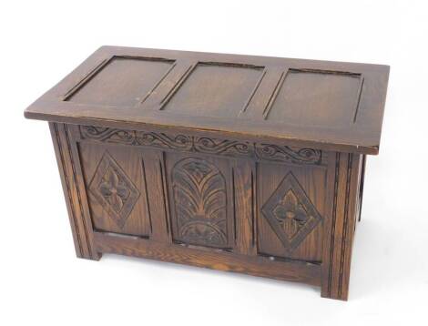 An oak coffer, with a carved panelled front, raised on fluted square legs, 48cm H, 84cm W, 45cm D.