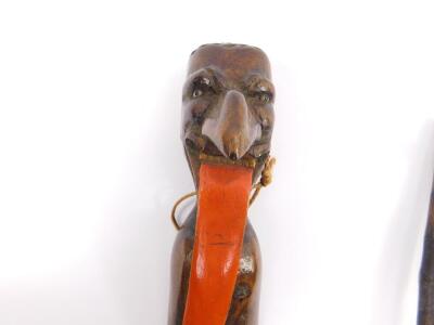 A late 19thC Continental meerschaum and wooden carved pipe, formed as a flower on stem, tip lacking, cased, 14.5cm L, a novelty figural pipe, 27cm L, a carved wooden paper knife, modelled with the head of Zanni from The Comedia Dell 'Arte, 42cm L, and a M - 2