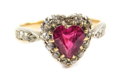 A Victorian ruby and diamond heart shaped ring, the heart shaped ruby in a surround of old cut diamonds, yellow and white metal shank with diamond set shoulders, size L, 3.0g.