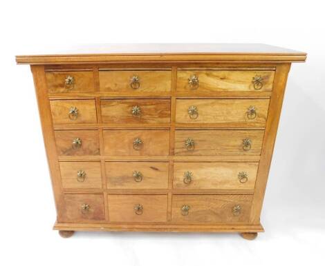 A mango wood and marble inlaid chest of drawers, the parquetry top over an arrangement of fifteen left to right graduated drawers, raised on bun feet, 95.5cm H, 114.5cm W, 50cm D.