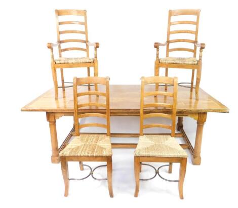 A mango wood and marble inlaid refectory dining table, the parquetry top raised on turned column supports united by fluted stretchers, 76cm H, 231cm W, 120cm D, together with six ladder back dining chairs, with rush seats, comprising a pair of carvers and