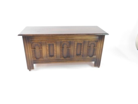 An Old Charm oak coffer, with a carved panelled front, retailers label for Wm Neal & Son Ltd, Bridlington., 55cm H, 114cm W, 43cm D.