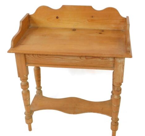 A Victorian pine washstand, with a galleried top, raised on turned and fluted legs united by stretchers with a shaped under shelf, 88cm H, 78cm W, 46cm D.