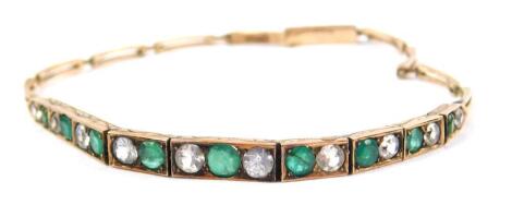 A white sapphire and emerald set bracelet, in yellow metal, on a snap clasp, 6.5g. (AF)