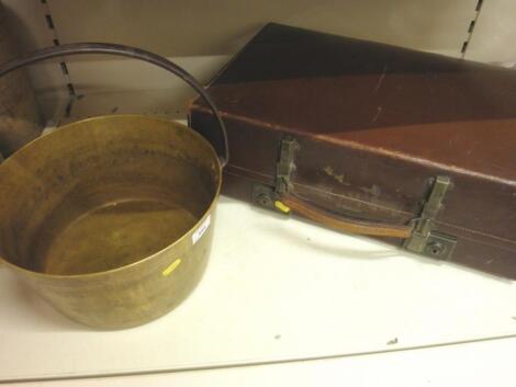 A leather suitcase and a brass pan