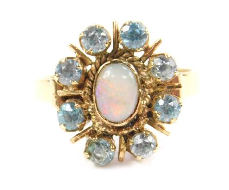 A 9ct gold opal and aquamarine ring, set with an oval cabachon opal in a surround of eight aquamarines, size L, 3.1g.