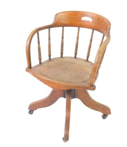 A Victorian oak captain's swivel armchair, with a bentwood seat, raised on a cast iron mechanism and four cabriole legs, on castors.