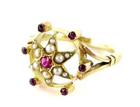 A Victorian style cluster ring, set with central star, set with garnet stones and seed pearls, with six point garnet to the outside with v split design shoulders, yellow metal unmarked, ring size M, 3.5g all in, boxed.