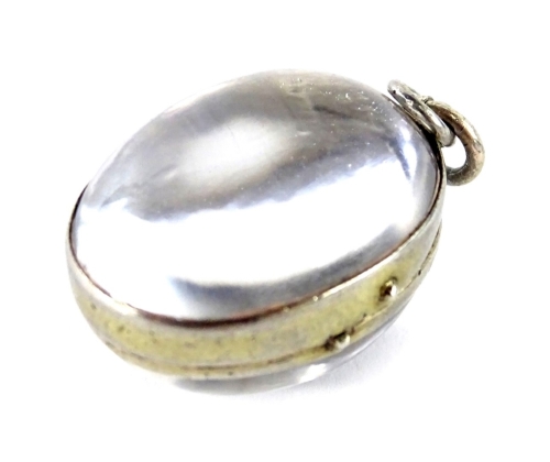 A silver framed rock crystal oval pendant, with plain design to the stone, 2.5cm H, 8.9g all in.