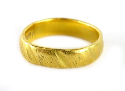 A 22ct gold wedding band, of polished and etched design, with makers stamp CG & S, numbered 877-7, ring size L½, (misshapen), 5.4g.