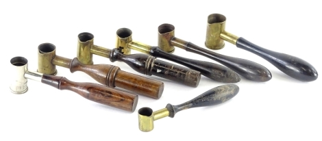 Various powder measures, in brass and steel with turned wood handles.