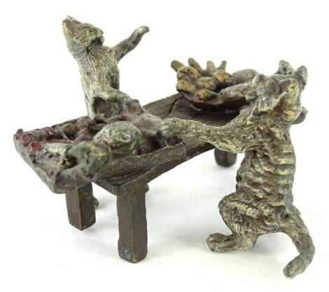 A small cold painted bronze group, depicting two cats preparing food, etc., at a table, bearing mark to underside for the Bergman factory, 8cm L.