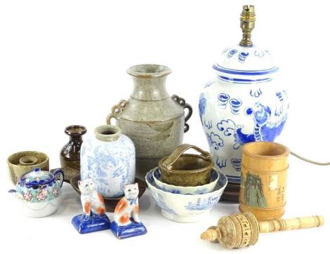 A collection of ceramics, etc., to include a Tibetan carved wooden prayer wheel, a pair of modern Staffordshire cats, 19thC Willow pattern bowls, studio pottery vase, oriental style table lamp, etc.