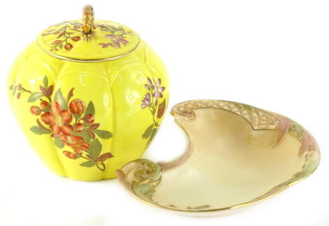 A Royal Worcester porcelain jar and cover, decorated with flowers, on a yellow ground, printed mark in puce to underside, (AF), and a crescent shaped blush ivory Royal Worcester dish. (2)