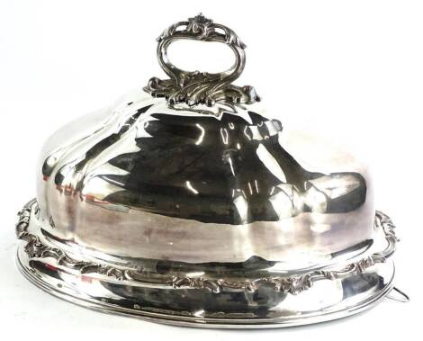 A silver plated meat dish cover, the handle cast with scrolls, etc., 43cm W.