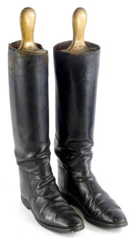 A pair of black leather riding boots and trees.