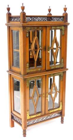 An unusual late 19th/early 20thC aesthetic style side cabinet, the fretwork galleried top, with urn shaped finials above two pairs of doors, each with geometric astragal's containing bevelled glass above a fretwork frieze on short turned legs, 120cm H, 29