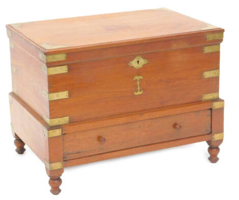 An Eastern teak and brass bound campaign type work box, the hinged lid enclosing a fitted interior above a drawer on short turned legs, 65cm W.