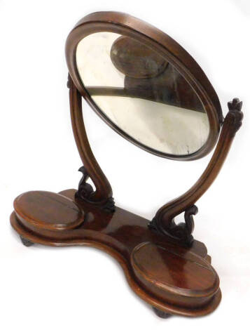 A Victorian mahogany swing frame dressing table mirror, with oval plate on shaped supports, the base with two hinged trinket compartments, on tapering feet, 71cm W.