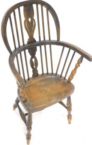 A child's Windsor chair, with a pierced splat, solid seat on turned legs, with H stretcher.