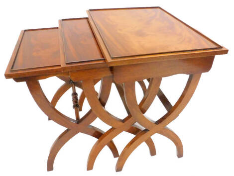 A nest of three mahogany occasional tables, each with a shallow gallery, on X shaped end supports, the largest 56cm W.